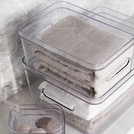 stablebare oppbevaringsbokser med håndklær og småting på bad