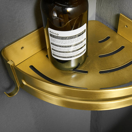 Hjørnehylle til dusj i gullfarget metall med plass til sjampo og såpe