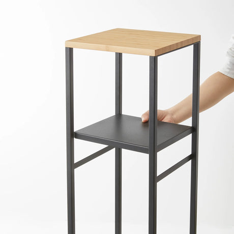 Sort oppbevaringshylle med bambusplate brukt til diffuser og bøker