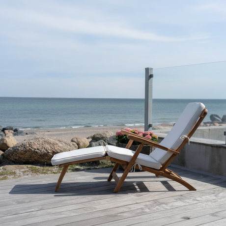 Arrecife dekkstol i teak med hvit pute på terrasse