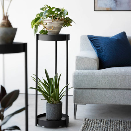 Sort stativ til planter med to runde flater og minimalistisk uttrykk
