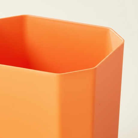 Nærbilde av orange plastinnsats til verktøykasse med solid plast og sekskantet form for smådeler