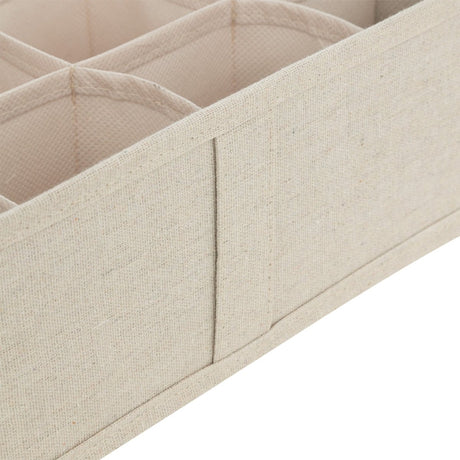 Nærbilde av beige skuffeorganiser med stofftrukne skillevegger og rominndeling.