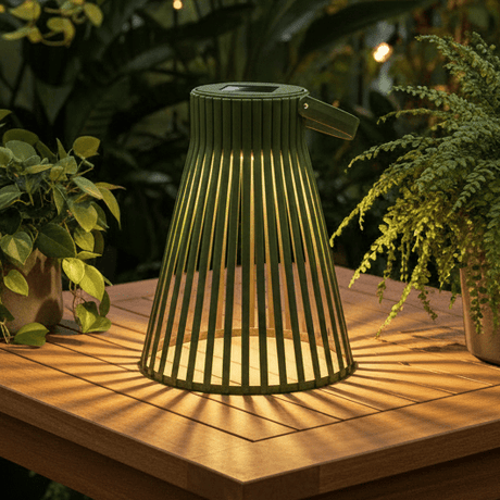 LED solarlykt på steinhelle ved vindu og grønne planter
