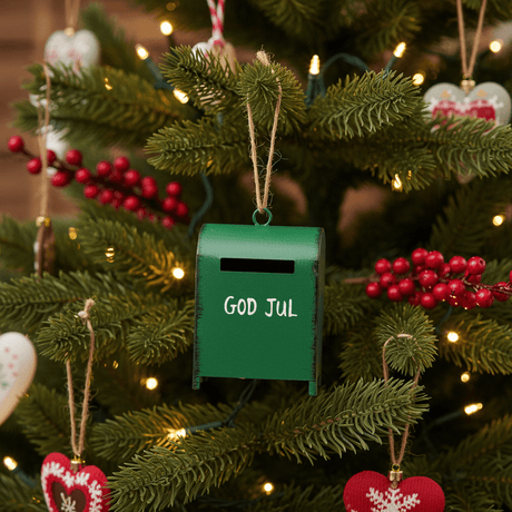 Julepynt med grön postkåsa och vit text för klassisk julstämning