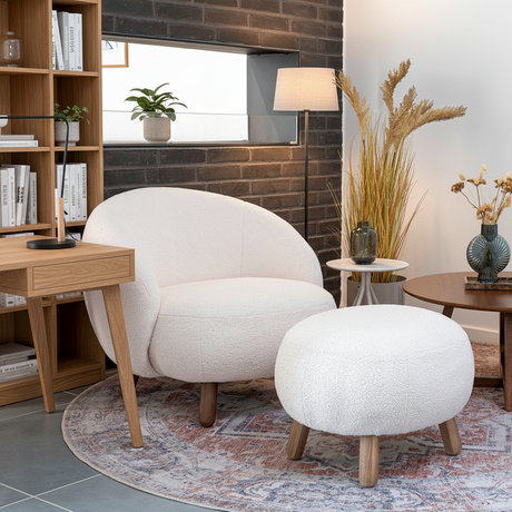 Loungestol og puff i hvit teddy som gir rommet en varm sitteplass