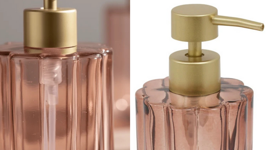 Nærbilde av rosa såpedispenser i riflet glass med gullfarget pumpe. Bildet viser pumpemekanismen og detaljene i glassbeholderen.