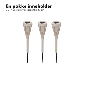 Beige solcellelykter med varmt lys i blomsterbed