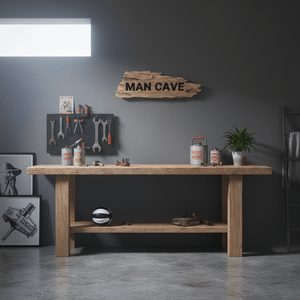 MAN CAVE skilt på mørk vegg over arbeidsplass for modellbygging med verktøy, hobbyutstyr og arbeidslampe.