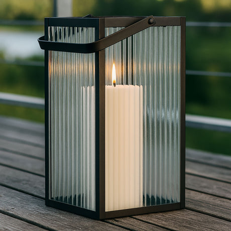 Almonte lykt med rillede glasspaneler og svart ramme – dekorativ utelykt med tent kubbelys, perfekt for stemningsfull uteplass eller terrasse.