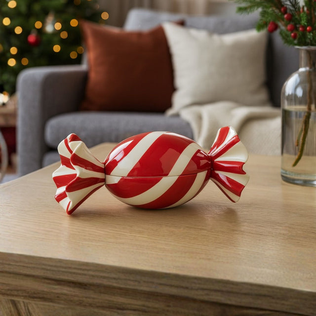 Rød og hvit keramisk juledekorasjon formet som en drops, plassert på stuebord i moderne julepyntet stue.