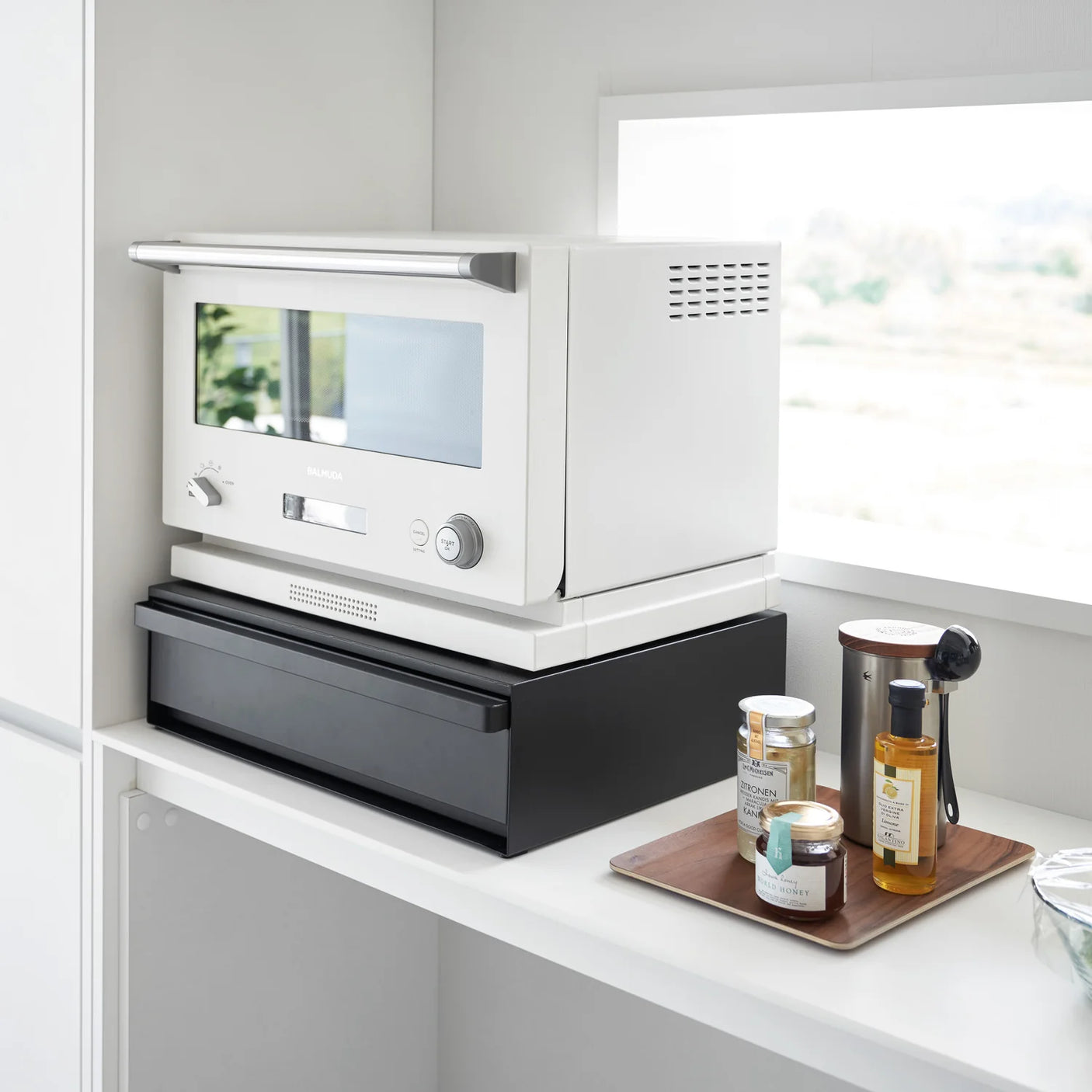 Sort kjøkkenhylle med skuff for organisering av apparater og tilbehør