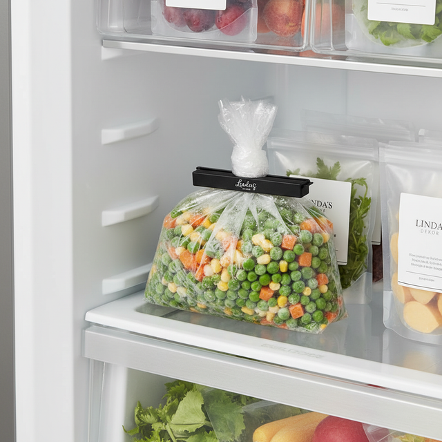 Svart poseklips som lukker frysepose med grønnsaker i kjøleskap – holder maten fersk og organisert