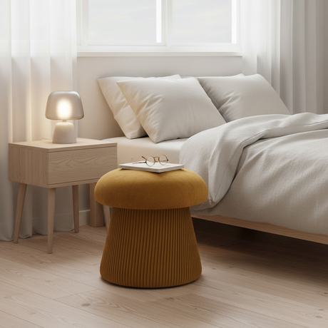 Oker puff plassert ved lenestol i lyst interiør