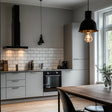 Moderne kjøkken med Uni Matt Grå kontaktplast på skapdørene og hvite fliser som gir et stilrent og tidløst uttrykk