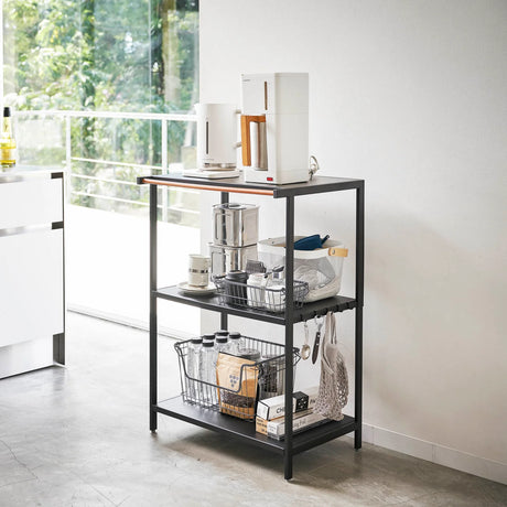 Romslig kjøkkenhylle i sort med plass til bokser, kopper og utstyr