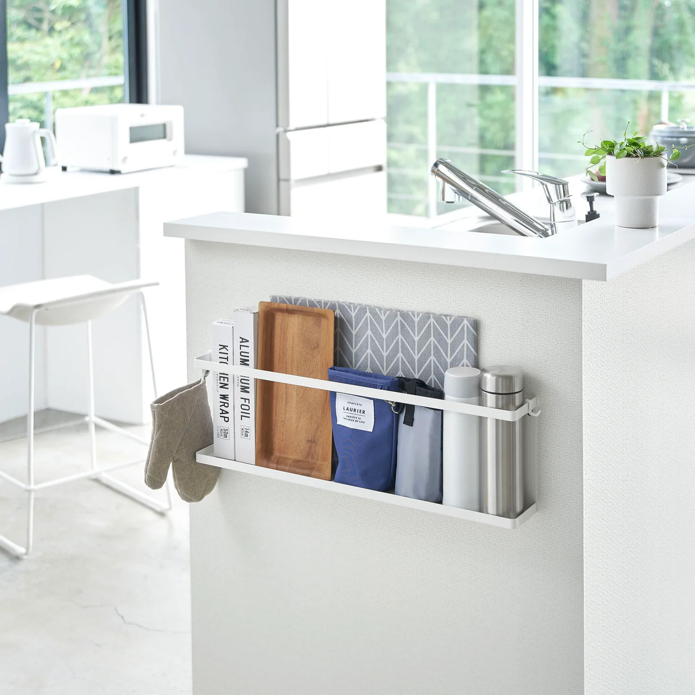 Hvit metallhylle til kjøkken med plass til skjærebrett og flasker