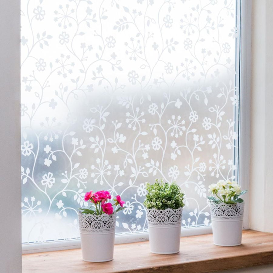 Vindusfolie med ranker og blomster på frosted overflate
