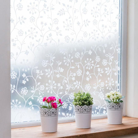 Vindusfolie med ranker og blomster på frosted overflate
