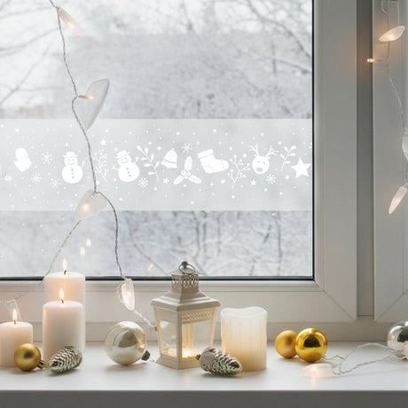 Julfolie på fönster med frostat mönster och tentlys framför